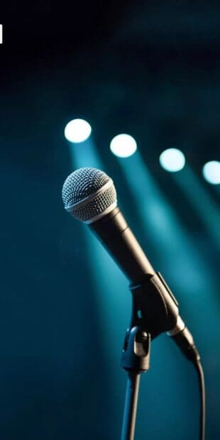 A classic microphone stands ready on a stage with blurred blue spotlights in the background, HD Phone Wallpaper