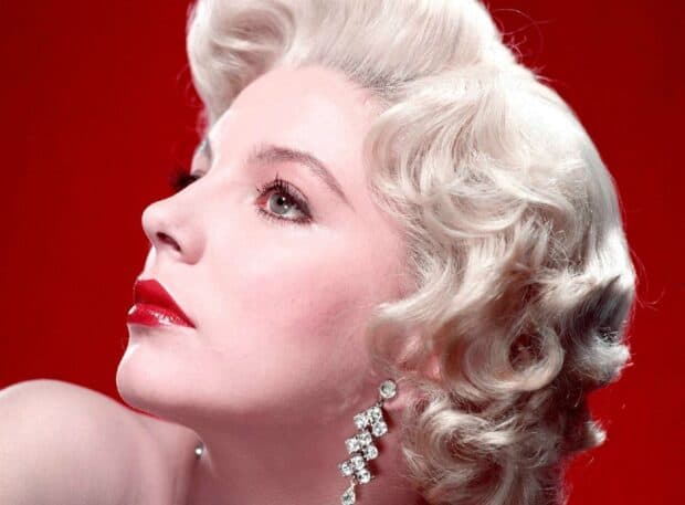 A close up profile of Joan Collins with blonde curls and red lipstick wearing sparkling earrings, HD Desktop Wallpaper