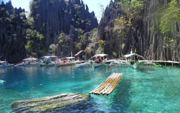 Traditional boats float in the clear waters of Palawan surrounded by towering cliffs, HD Desktop Wallpaper