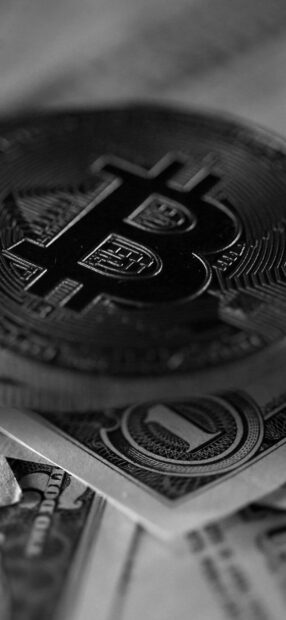 A close up of Bitcoin digital currency on US dollar bills showing financial contrast, HD Phone Wallpaper