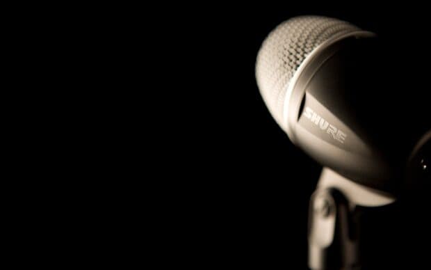 A close up of a Shure microphone against a dark background, 2K Desktop Wallpaper