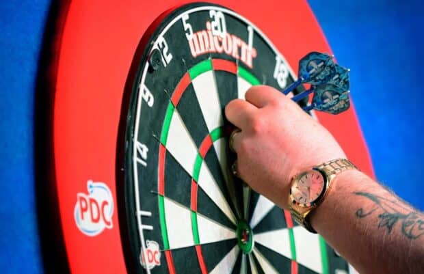 A hand with darts near the center of the dartboard during a game, HD Desktop Wallpaper