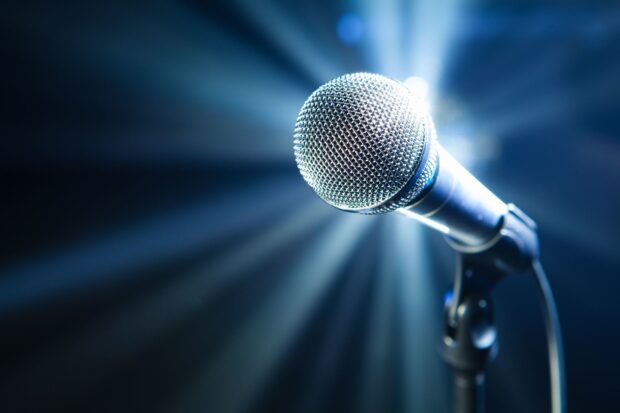 A close up of a professional microphone with light rays shining behind it on stage, HD Desktop Wallpaper