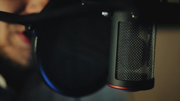 A close up of a professional microphone with a pop filter for recording audio, 4K Desktop Wallpaper