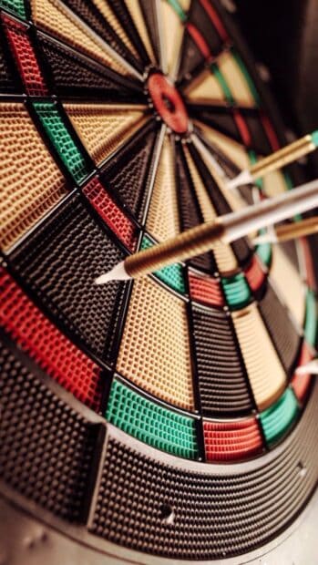 A close up view of a darts board showing darts hitting the target area accurately, HD Mobile Wallpaper