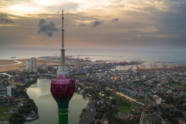 The city of Colombo Sri Lanka is shown with the Lotus Tower by the river and harbor under a cloudy sky, HD Desktop Wallpaper