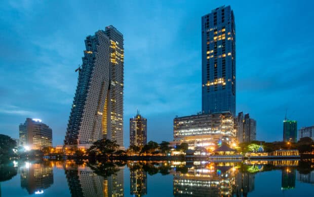 The Colombo Sri Lanka Wallpapers city skyline is reflected in the calm water during evening blue hour, HD Desktop Wallpaper