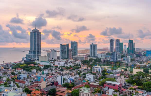 The Colombo cityscape in Sri Lanka shows high rise buildings and ocean at sunset, HD Desktop Wallpaper