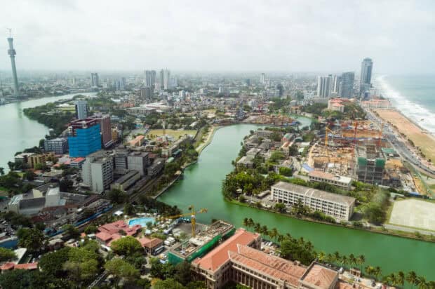 A scenic view of Colombo Sri Lanka with a river flowing through the city and various buildings, HD Desktop Wallpaper