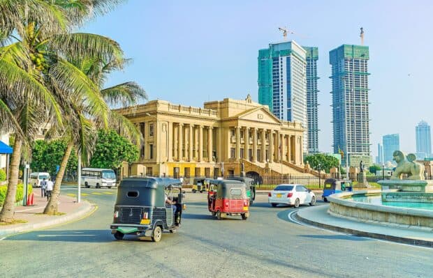 The busy street in Colombo Sri Lanka shows tuk tuks and historic buildings during the day, 2K Desktop Wallpaper
