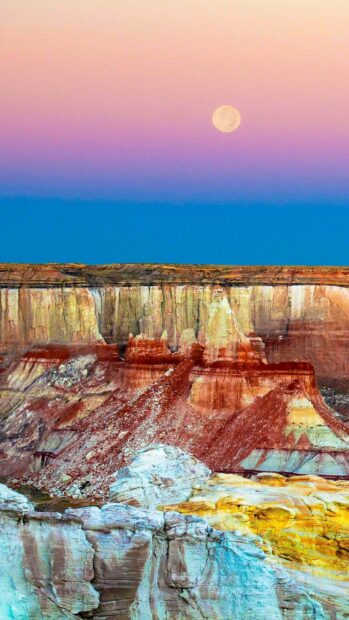 Colorful Grand Canyon under full moon Grand Canyon showcases vibrant rock formations beneath a full moon in the evening sky 2K Phone Wallpaper