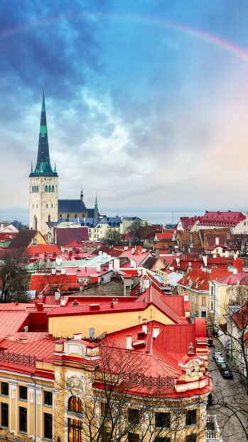 A vibrant view of Estonia features red rooftops and a rainbow over historic buildings, HD Mobile Wallpaper