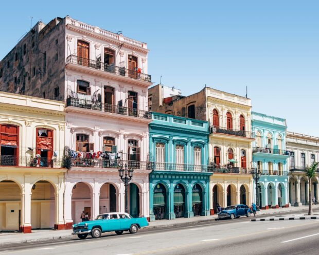 A street view of colorful colonial style buildings with vintage cars in Havana Cuba, 2K Desktop Wallpaper