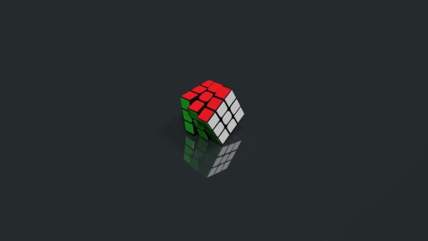 A colorful cube puzzle shows its red white and green sides on a reflective dark surface, HD Desktop Wallpaper