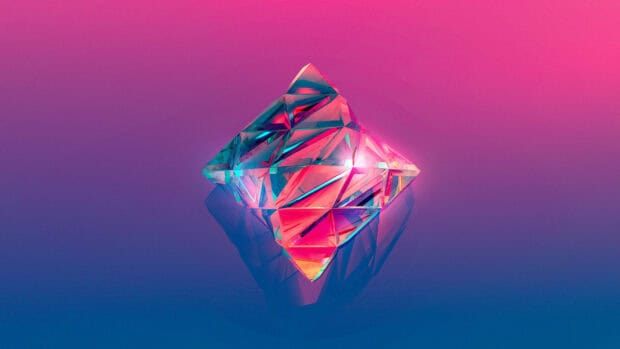 A faceted crystal with vibrant pink and blue hues reflecting on a smooth surface, 2K Desktop Wallpaper