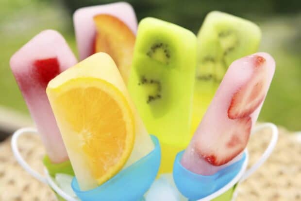 A close up of colorful popsicles with fresh fruit slices freezing inside vivid ice, HD Desktop Wallpaper