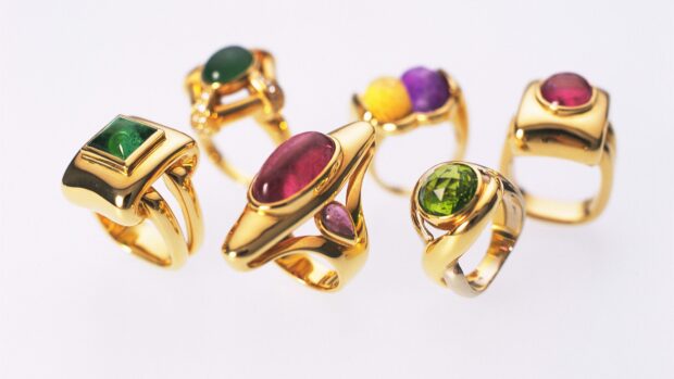 A collection of jewelry with colorful gemstones on gold rings, 4K Desktop Wallpaper