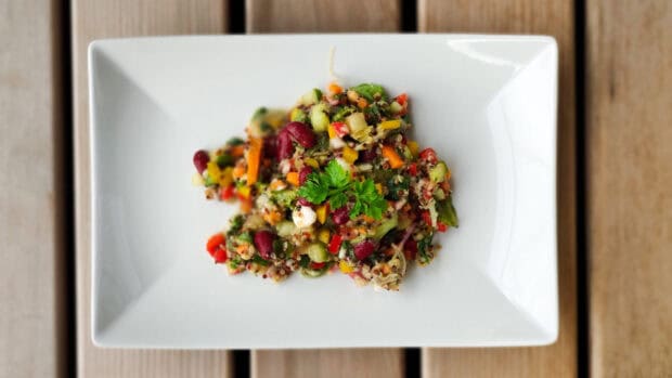 A colorful quinoa salad with beans and vegetables on a white plate, 2K Desktop Wallpaper