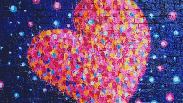 A vibrant heart shape painted with dots on a brick wall, HD Desktop Wallpaper