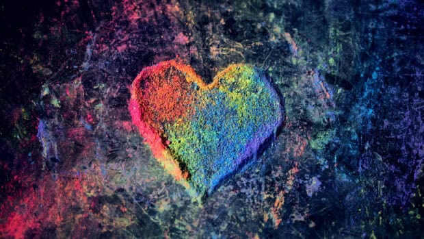 A colorful heart shape created with bright pigments on a dark surface, 4K Desktop Wallpaper