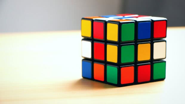 A colorful cube puzzle shows various bright colors on a light wooden surface, HD Desktop Wallpaper