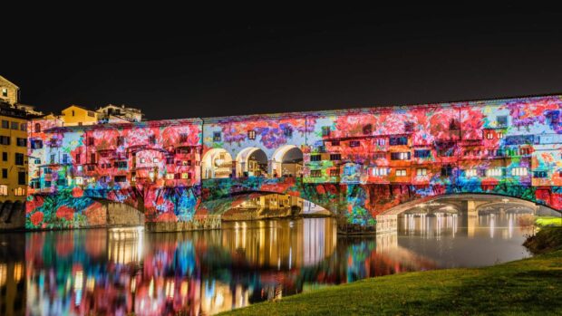 The Ponte Vecchio is lit up with vibrant colors reflecting in the river, HD Desktop Wallpaper