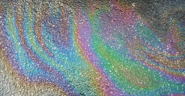 Colorful oil film creates holographic patterns on the wet pavement surface, HD Desktop Wallpaper
