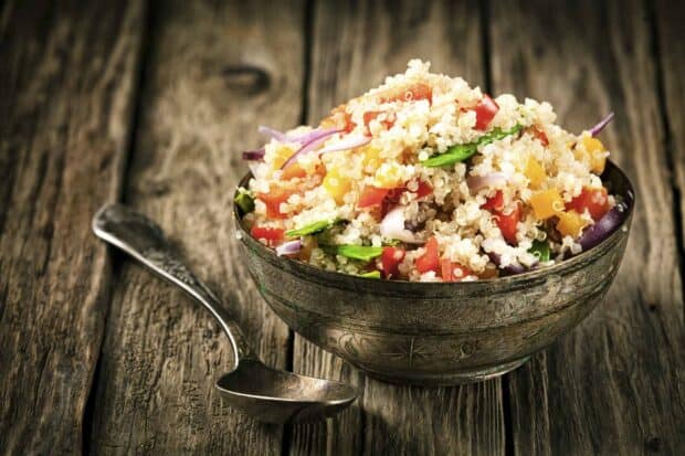 A bowl of quinoa salad with tomatoes, bell peppers, and greens on a wooden table, HD Desktop Wallpaper