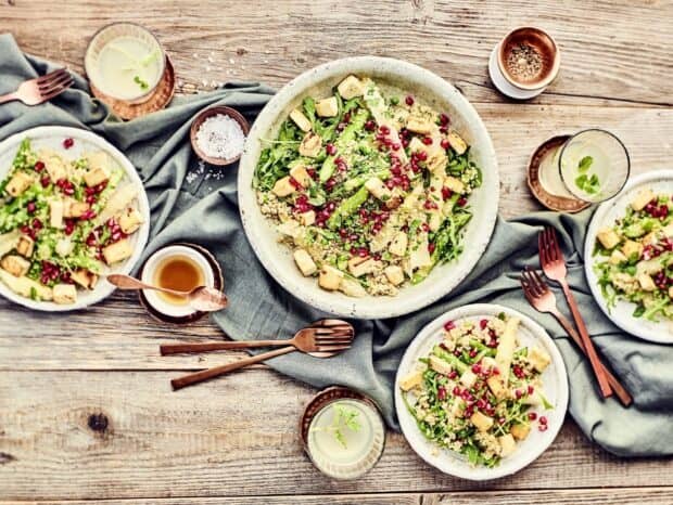 A healthy quinoa salad with pomegranate seeds and tofu on a wooden table, HD Desktop Wallpaper