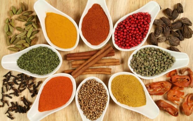 Various seasoning wallpapers displayed in white spoons on a wood surface, 2K Desktop Wallpaper