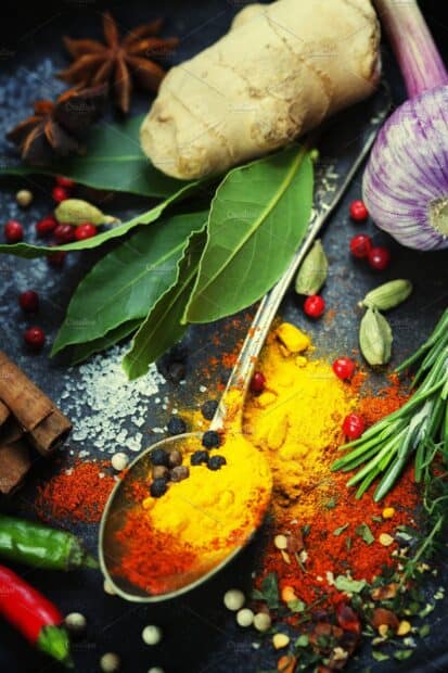 A spoon filled with vibrant seasoning shows fresh herbs and spices on a dark surface, 2K Mobile Wallpaper