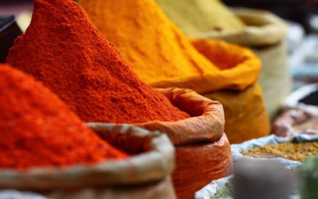 A variety of seasoning powders in bags displayed at a market, 2K Desktop Wallpaper