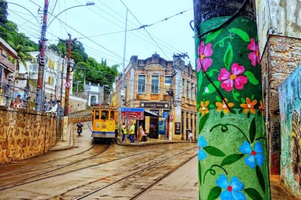 A tram passes through a vibrant street with painted pillars in Rio De Janerio Wallpapers, 2K Desktop Wallpaper