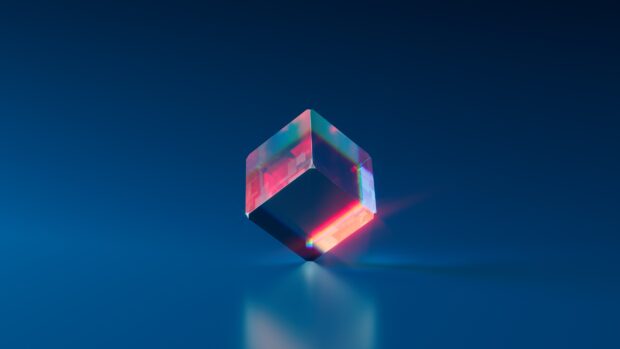 A colorful transparent cube glowing with vibrant light on a blue surface, 4K Desktop Wallpaper