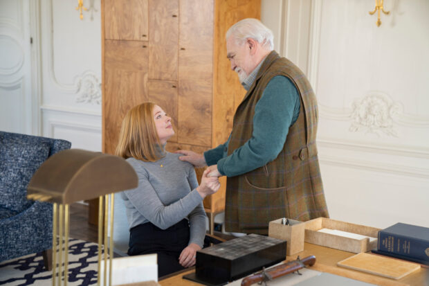 A woman warmly holding hands with an elderly man in a cozy room featuring Sarah Snook Wallpapers, HD Desktop Wallpaper