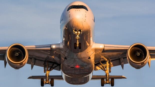 An aircraft flying low with landing gear extended under a clear sky, 4K Desktop Wallpaper