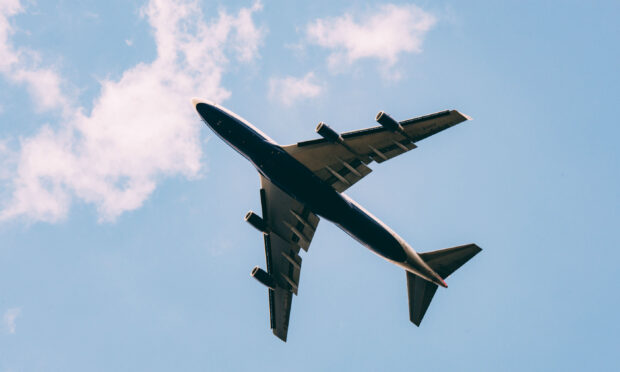 A commercial aircraft is flying under a partly cloudy sky in this aircraft wallpapers image, 2K Desktop Wallpaper
