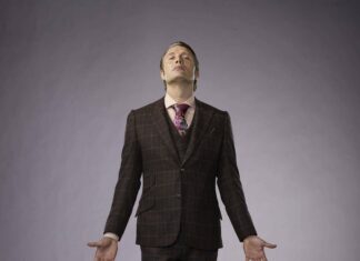 Hannibal Mads Mikkelsen stands with arms open in a dark suit, HD Desktop Wallpaper