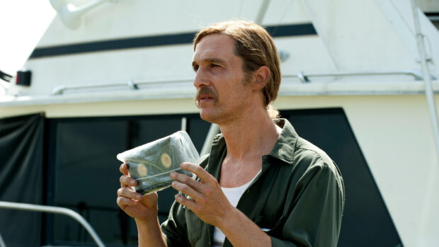 A detective carefully inspects a plastic wrapped package while standing near a boat, HD Desktop Wallpaper