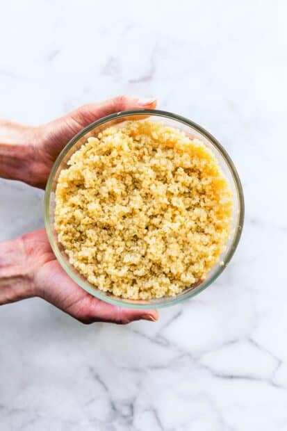 Cooked quinoa held in hands over a marble surface, HD Mobile Wallpaper