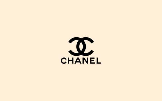 The image shows an elegant black Chanel logo on a beige background with cool girly wallpapers style, 2K Desktop Wallpaper