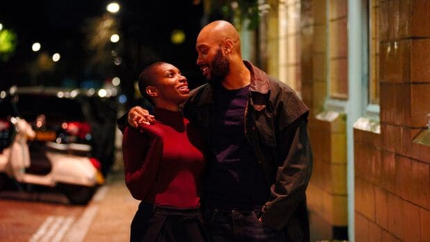A couple enjoys a warm embrace on a quiet street at night in Michaela Coel Wallpapers, HD Desktop Wallpaper