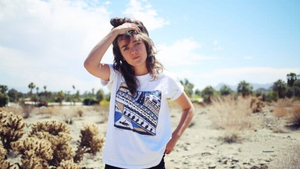 A casual portrait of Courtney Barnett standing outdoors under blue sky, HD Desktop Wallpaper