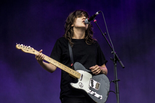 Courtney Barnett is singing and playing guitar during a concert, HD Desktop Wallpaper