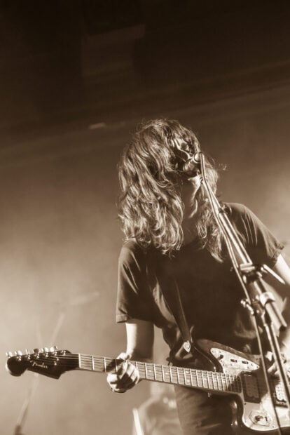 Courtney Barnett performing on stage with guitar and microphone, 2K Phone Wallpaper