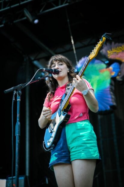 Courtney Barnett is performing live with her guitar singing into a microphone, HD Mobile Wallpaper