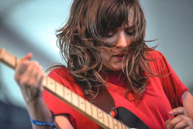 Courtney Barnett playing guitar intensely during a live performance, HD Desktop Wallpaper