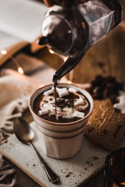 A cup of hot cocoa with marshmallows being poured and chocolate shavings on top with Cocao Wallpapers, HD Mobile Wallpaper