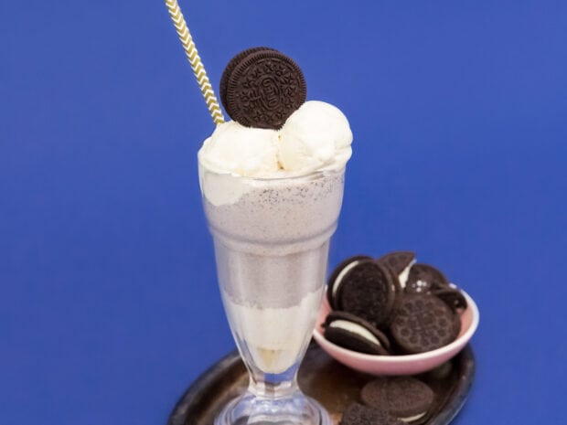 A creamy milkshake with cookies is served in a glass against a blue background, HD Desktop Wallpaper