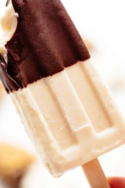 A close up of a creamy popsicle partially covered in chocolate held by hand, HD Mobile Wallpaper